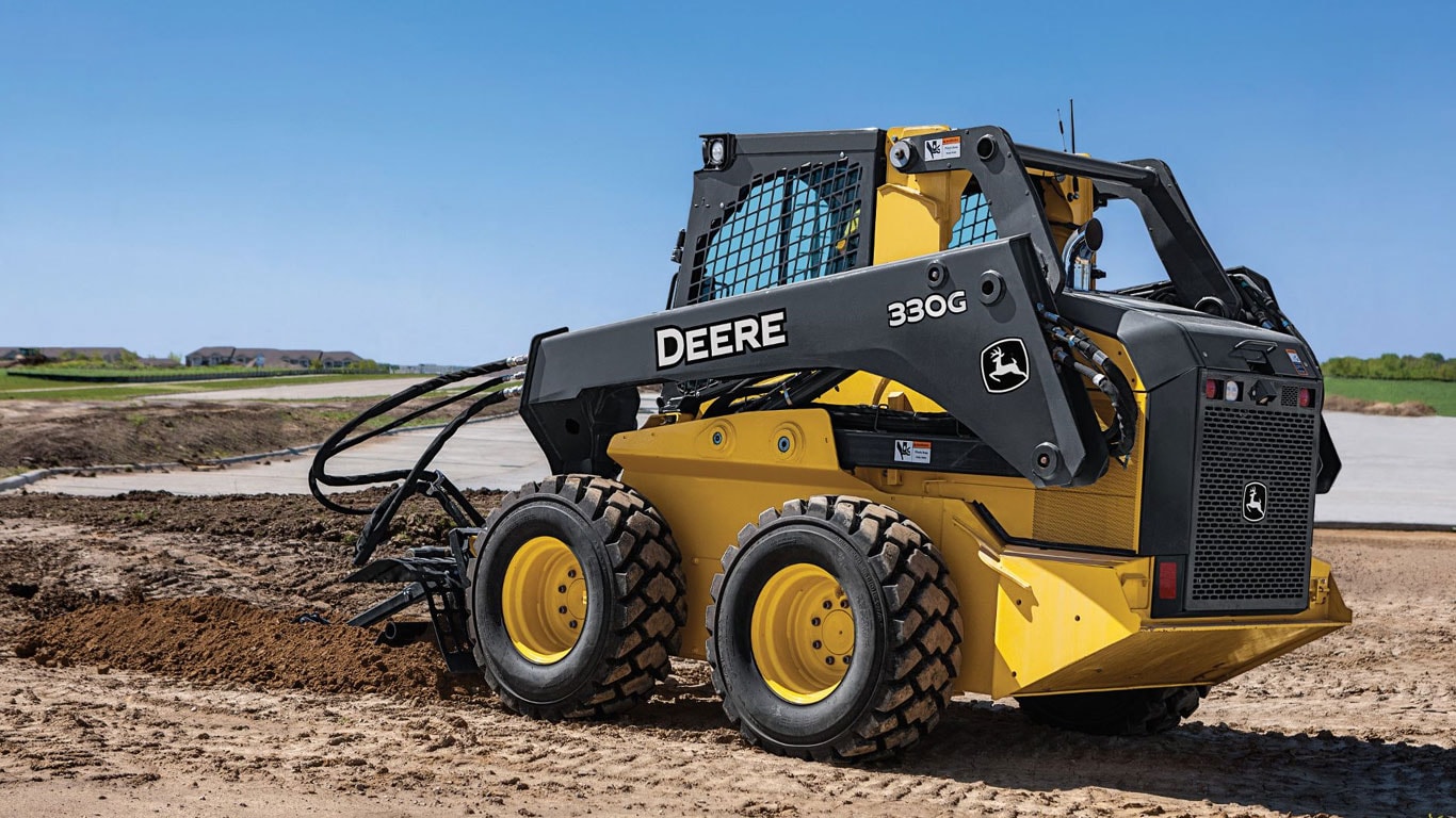 John Deere Skid Steer with Trencher Attachment working on jobsite.